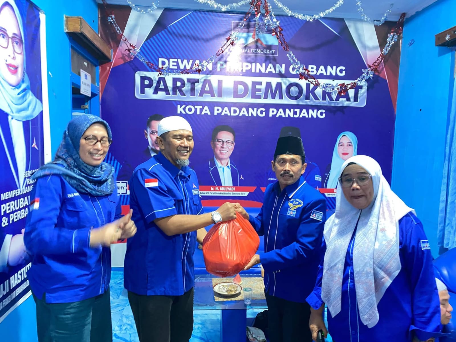 Ketua DPC Demokrat  H Fakhrudi saat serahkan paket pada kader.